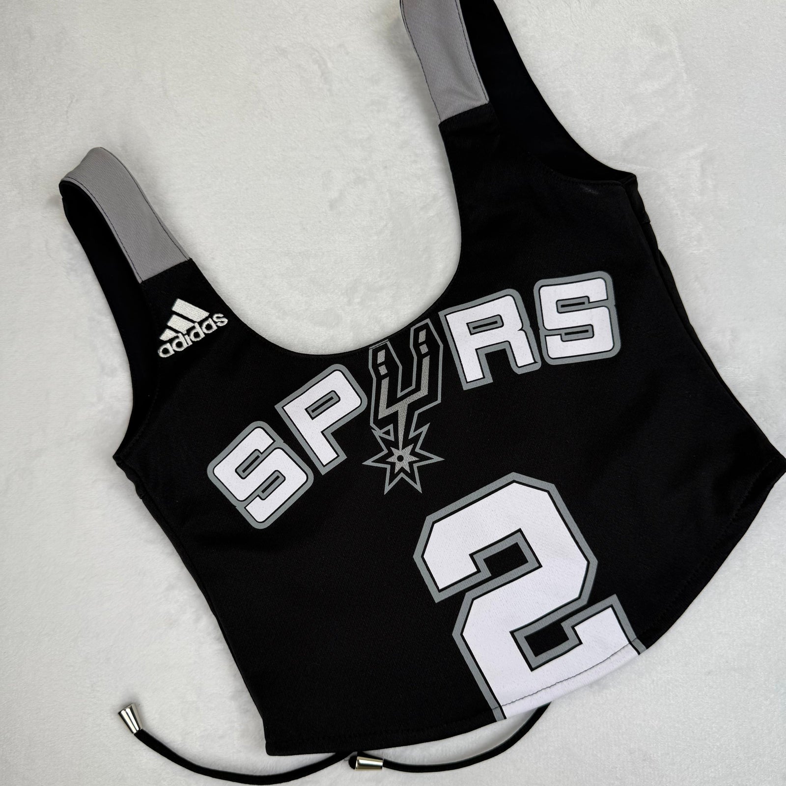 Spurs tank top with bold team branding, a sporty crop style, and a revamped sustainable design for dedicated fans.